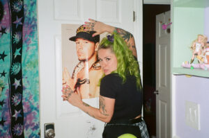Phoebe from Stay Weird Vintage poses with a 90s poster.